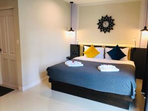 a bedroom with a bed with two towels on it at Ingnam Pool Villa in Krabi town