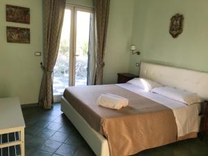1 dormitorio con 1 cama y puerta corredera de cristal en Agriturismo Borgo San Biagio, en Calatabiano