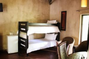 a bedroom with a bed and a dresser at AmaZulu Lodge in St Lucia
