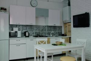 cocina con armarios blancos y mesa blanca en Flat in cottage close to the centre parking, WiFi, BBQ, en Leópolis