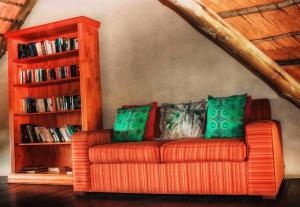 un sofá naranja con almohadas verdes en la sala de estar. en AmaZulu Lodge, en St Lucia