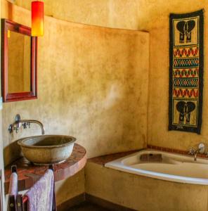 a bathroom with a sink and a bathtub at AmaZulu Lodge in St Lucia
