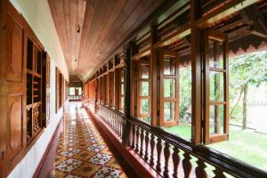 um corredor de uma casa com janelas e piso de azulejo em Chittoor Kottaram Royal Mansion- CGH Earth em Cochin