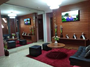 Una sala de estar con un sofá y un televisor en una pared. en Tamaris Hotel, en Chiclayo