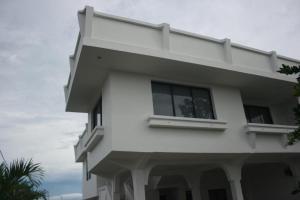 a white house with a window on the side of it at Yaya's House in Posorja