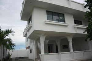 a white house with a palm tree in front of it at Yaya's House in Posorja