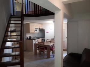une cuisine et une salle à manger avec un escalier en colimaçon dans l'établissement VVF Résidence Anglet, à Anglet