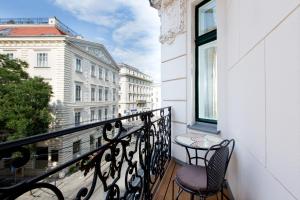 a balcony with two chairs and a table and a window at Vienna Residence, City Hall - Parliament in Vienna