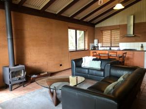 a living room with a couch and a stove at Marima Cottages in Pemberton