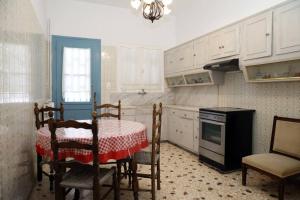 a kitchen with a table and chairs and a stove at Andreas Naxos Center - House in Naxos Chora