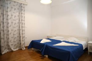 a bedroom with a bed with blue sheets and white pillows at Andreas Naxos Center - House in Naxos Chora