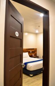 a door leading to a bedroom with a bed at Hotel Lourdes in Laoag
