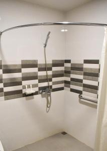 a shower in a bathroom with black and white stripes at Hotel Lourdes in Laoag