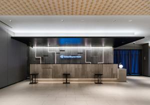 a lobby with two stools and a sign on a wall at Daiwa Roynet Hotel Tokyo Kyobashi PREMIER in Tokyo