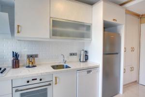 a white kitchen with a sink and a refrigerator at Emirganlı Suites in Istanbul