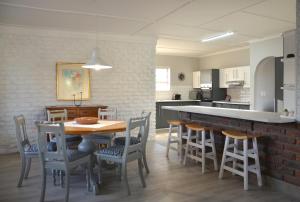 a kitchen and dining room with a table and chairs at Beach Blessings, Fun in the sun in Stilbaai