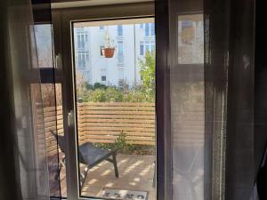 a sliding glass door with a chair on a patio at Black & Wood Design FeWo im Zentrum in Cottbus