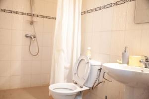 a bathroom with a toilet and a sink at Quintal di Maria in Guediawaye +26 photos
