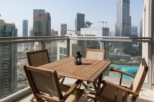 a table and chairs on a balcony with a view of the city at HiGuests - Charming Apt with Terrace Facing Burj Khalifa in Dubai