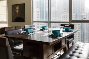 a dining room table with chairs and a large window at HiGuests - Charming Apt with Terrace Facing Burj Khalifa in Dubai