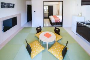 a living room with a table and chairs and a bedroom at momo premium 202 in Sapporo