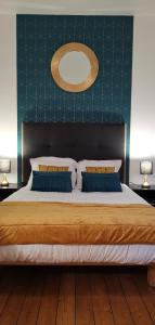 a bedroom with a large bed with two pillows at Logis Hotel La Tourelle du Beffroi in Bourbon-Lancy