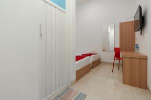 a bedroom with a bed and a desk and a chair at RedDoorz @ Graha Cemerlang Maros in Makassar +16 photos