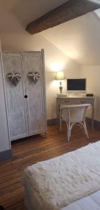 a bedroom with a desk with a computer and a bed at Logis Hotel La Tourelle du Beffroi in Bourbon-Lancy