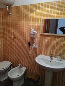 bagno con lavandino, servizi igienici e specchio di Next Stop Affittacamere Casilino a Roma