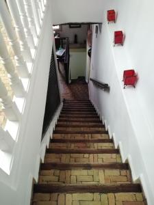 eine Treppe, die zu einem Zimmer mit roten Stühlen führt in der Unterkunft Dar El Paco in Essaouira