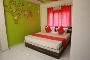 a bedroom with a bed with green walls and a window at Hotel Holydon in Siliguri