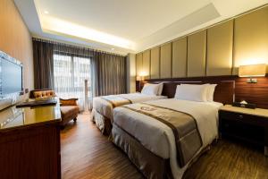 台北的住宿－豪城商旅民生館，酒店客房设有两张床和一台平面电视。
