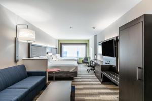 um quarto de hotel com uma cama e um sofá em Holiday Inn Express & Suites Jersey City North - Hoboken, an IHG Hotel em Jersey City