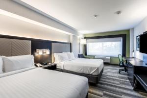 a hotel room with two beds and a flat screen tv at Holiday Inn Express & Suites Jersey City North - Hoboken by IHG in Jersey City +20 photos
