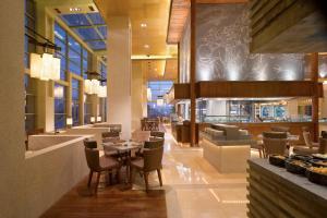 a restaurant with a table and chairs and a bar at Wyndham Grand Tianjin Jingjin City in Tianjin