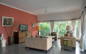 uma sala de estar com um sofá e uma televisão em Villa Paradise Lovina em Temukus