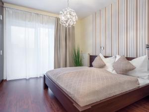 una camera con un grande letto e un lampadario a braccio di Alpe Adria Apartments - Top 1 by S4Y a Faak am See