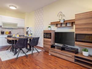 a living room with a table and a flat screen tv at Alpe Adria Apartments - Top 1 by S4Y in Faak am See +13 photos