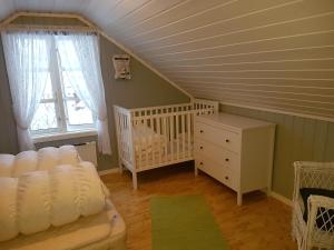 um quarto para bebés com um berço, uma cama e uma janela em Rabben Feriested em Lyngværet