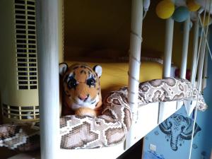 - un tigre farci assis dans un lit superposé dans l'établissement Chambres d'hôtes du Port aux Cerises, à Vigneux-sur-Seine