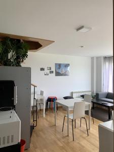 a living room with tables and chairs and a tv at Pension 23-Vinte e Tres in O Pedrouzo