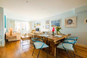 ein Wohnzimmer mit einem Holztisch und Stühlen in der Unterkunft Shell Cottage in Aldeburgh