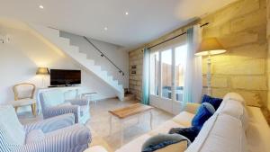 a living room with a couch and chairs and a tv at Le Mas de Guiguite in Mézoargues