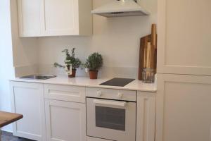 Una cocina con gabinetes blancos y encimera. en STUDIO in the CITY, en La Valeta