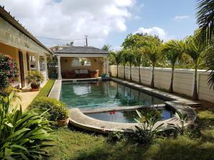 a swimming pool in the yard of a house at Villa Turquoise in Cap Malheureux