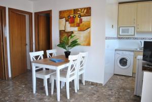 a kitchen with a table and a refrigerator at Carihuela Park Palace - Cocasa in Torremolinos