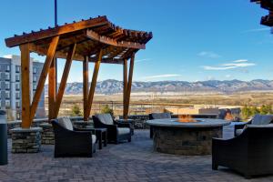 een patio met een tafel en stoelen en een vuurplaats bij Staybridge Suites Denver South - Highlands Ranch, an IHG Hotel in Littleton