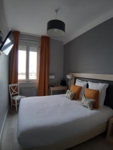 a bedroom with a large white bed and a window at Les Embruns in Trouville-sur-Mer
