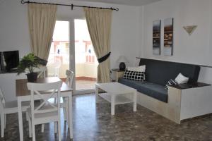 a living room with a couch and a table and chairs at Carihuela Park Palace - Cocasa in Torremolinos