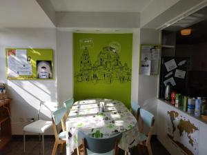 ein Esszimmer mit einem Tisch und einer grünen Wand in der Unterkunft La Casa Verde in Murcia